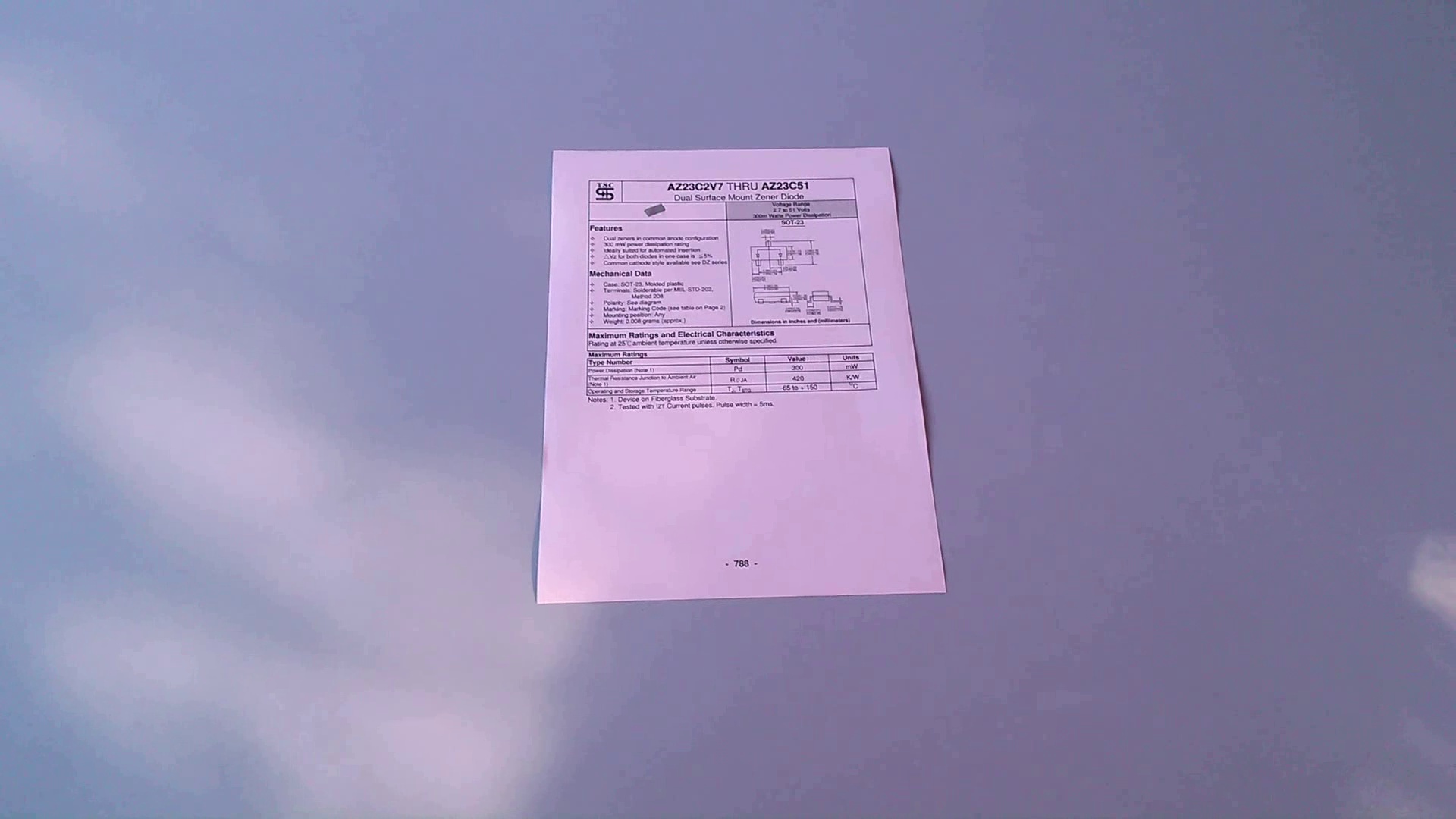 Angled phone photo of a printed datasheet on a desk